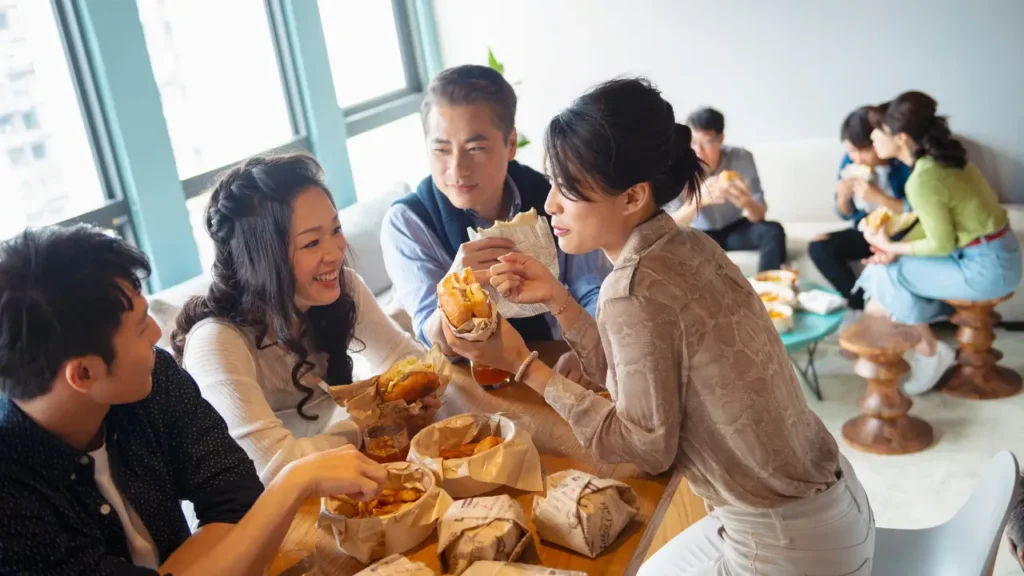 Co-workers treating each other like family members in a team lunch out - improving employee morale